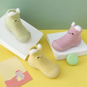 Detail von dicken Nerzsamt-Lauflernschuhen für Babys mit Cartoon-Bärenohren in Farben.
