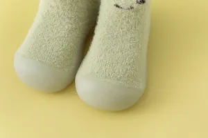 Nahaufnahme von weichen, flauschigen Baby-Socken-Schuhen mit schützenden Gummikappen.