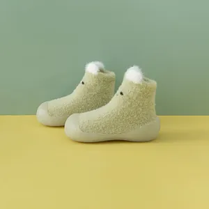 Nahaufnahme von grünen Plüsch-Lauflernschuhen für Babys mit süßen weißen Bärenohren.
