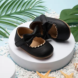 Detailweergave van zwarte baby prinsessenschoenen met leren strik en geschulpte rand