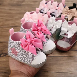 Primer plano de lindos zapatos para bebé niña con estampado de leopardo y lazos rosas