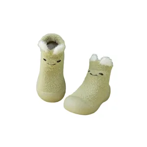 Nahaufnahme grüner Plüsch-Babyschuhe mit 3D-Bärenohren und süßem Cartoon-Gesicht