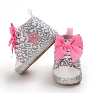 Primer plano de zapatos para bebé con estampado de leopardo, grandes lazos y purpurina