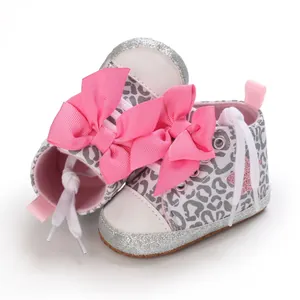 Vista detallada de zapatillas para bebé niña con estampado de leopardo y lazos rosas