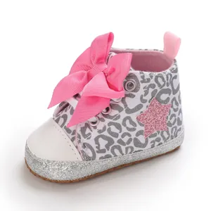 Detalle de zapato para bebé niña con estampado de leopardo, lazo rosa grande y una estrella