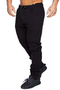 Close-up of black men's athletic joggers featuring ribbed moto knee panels and drawstring waist