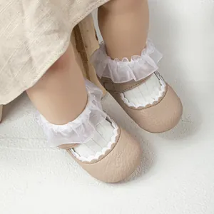 Detailopname van babymeisjesschoenen met witte ruches en zachte lederen textuur