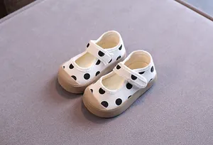 Vue détaillée de chaussures de marche pour bébé à pois blancs avec semelles souples