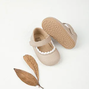 Detail van beige baby Mary Jane schoenen met golvende rand en antislip rubberen zool