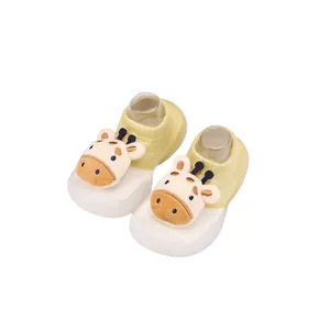Detailaufnahme von Babysocken-Schuhen mit einer 3D-Giraffenpuppe auf weißer Gummisohle.