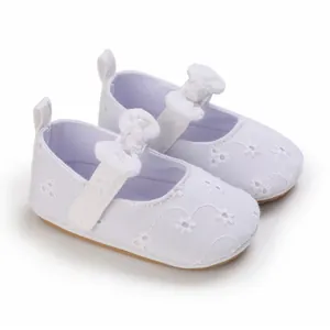 Detalle de zapatos de princesa para bebé blancos con suela blanda y bordados