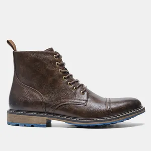 Detalle lateral de botas Martin marrones para hombre con textura de cuero y suela azul.