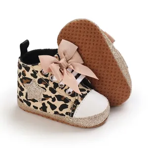 Vista detallada de zapatos de bebé con estampado de leopardo, lazo y estrella.