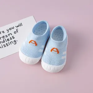Detailed macro view of blue breathable knit baby walking shoes with soft white rubber soles.