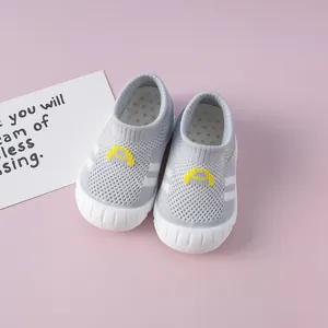 Close-up of breathable grey knit baby walking shoes with soft white rubber soles.