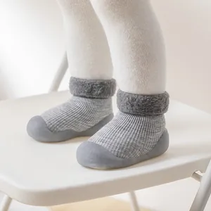 Detailansicht warmer grauer Baby-Schneesocken-Schuhe mit weichem Plüschkragen auf Stuhl.