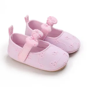 Vista detallada de zapatos Mary Jane rosas para bebé con bordado floral y lazos suaves