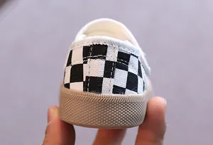 Vue détaillée du talon à damier noir et blanc sur une chaussure de marche pour bébé à semelle souple