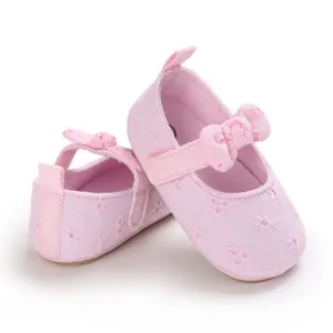 Detalle del bordado floral y el lazo en los zapatos de princesa rosas para bebé