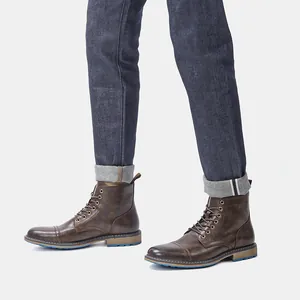 Vista lateral de botas Martin de cuero marrón combinadas con pantalones vaqueros.