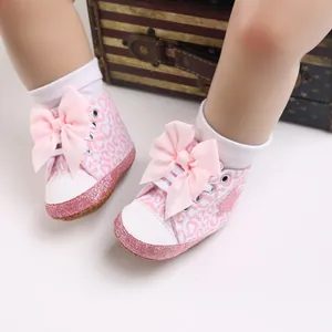 Detalle de zapatos para bebé niña con estampado de leopardo rosa y lazo grande
