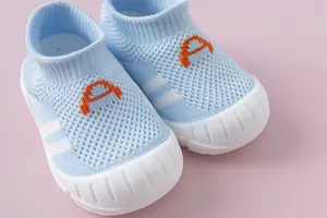 Macro view of blue baby walking shoes with breathable flyknit mesh and soft white rubber sole