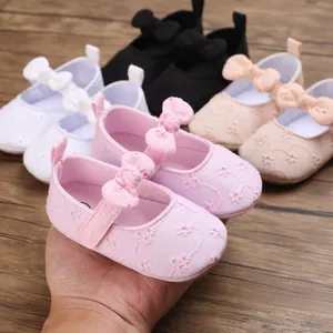 Detalle de los zapatos de princesa para bebé bordados con hermosas flores rosas y lazos