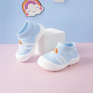 Close-up of light blue knitted baby sock shoes featuring flexible soft white soles.