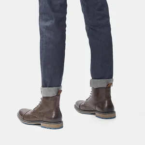 Vista lateral de botas de trabajo marrones de alta calidad para hombre con suela azul
