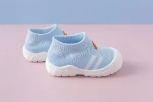 Side detail of light blue breathable knitted baby walking shoes featuring soft white soles