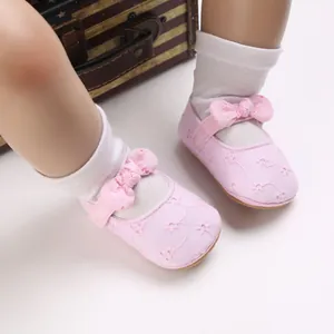 Detalle de zapatos rosa de princesa para bebé con suela blanda y bordado de flores.