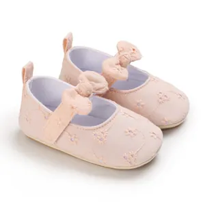 Vista detallada de zapatos de princesa rosa para bebé con bordados florales y suela suave