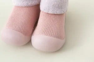 Detail von rosa gestrickten Baby-Laufsocken mit weichen Gummisohlen und Fleecefutter