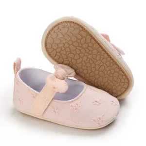 Detalle de zapatos rosa de princesa para bebé con bordado floral y suela blanda antideslizante.