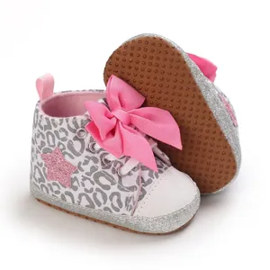 Primer plano de zapatos de bebé con lazo rosa, estampado de leopardo y suela con purpurina