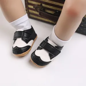 Close-up of black and white baby leather walking shoes featuring anti-slip soles