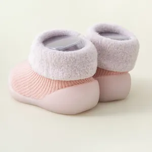 Detail eines rosa gestrickten Babylauflernschuhs mit weicher Sohle und Größenprägung