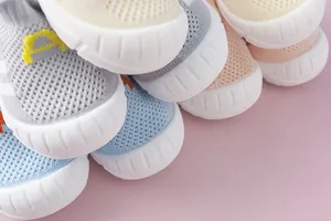 Macro view of baby flyknit walking shoes with soft soles in various pastel colors