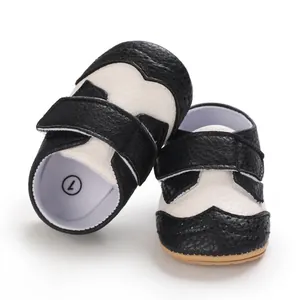Close-up detail of black and white faux leather baby toddler shoes with Velcro closure