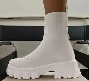 Détail latéral d'une bottine chaussette blanche à plateforme épaisse et semelle crantée.