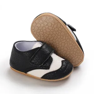 Detail view of black and white non-slip infant walking shoes with soft rubber sole.