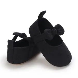 Detalle de zapatos de princesa para bebé con suela blanda negra y bordado floral