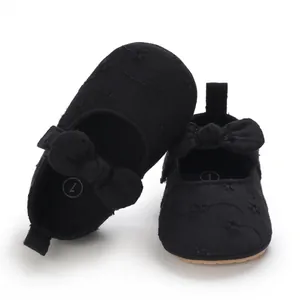 Primer plano de zapatos de princesa para bebé negros con bordado y lazo