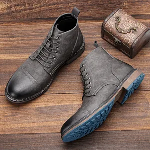 Vista detallada de botas de trabajo grises para hombre con suelas de tracción azul.