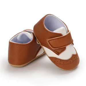 Classic brown and white wingtip baby walking shoes featuring a secure velcro strap