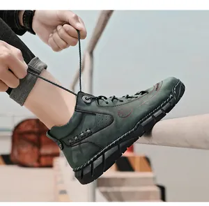 Close-up detail of men's dark green high-top leather work boots with lace-up design.