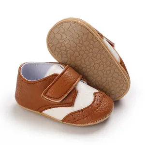 Close-up detail of brown and white baby walking shoes featuring non-slip rubber sole