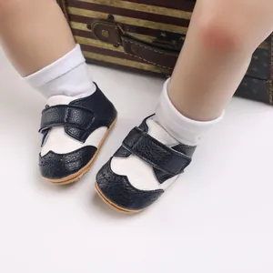 Close-up of black and white baby walking shoes with anti-slip rubber soles for toddlers.