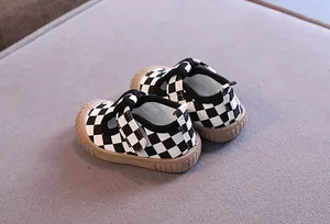 Close-up of black and white checkered baby walker shoes with soft non-slip sole