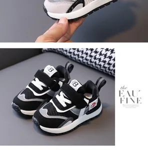 Detailed view of black and white breathable mesh toddler sneakers with velcro straps.